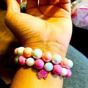 Pink beaded acrylic bracelet with charm.